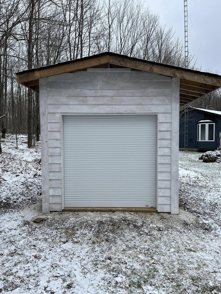 A white rollshutter installed on an external shed protecting from breakins and severe weather. This rollshutter also offers a level of insulation and temperature regulation.