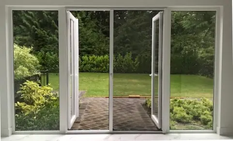 A VistaView retractable screen door looking out onto a backyard.